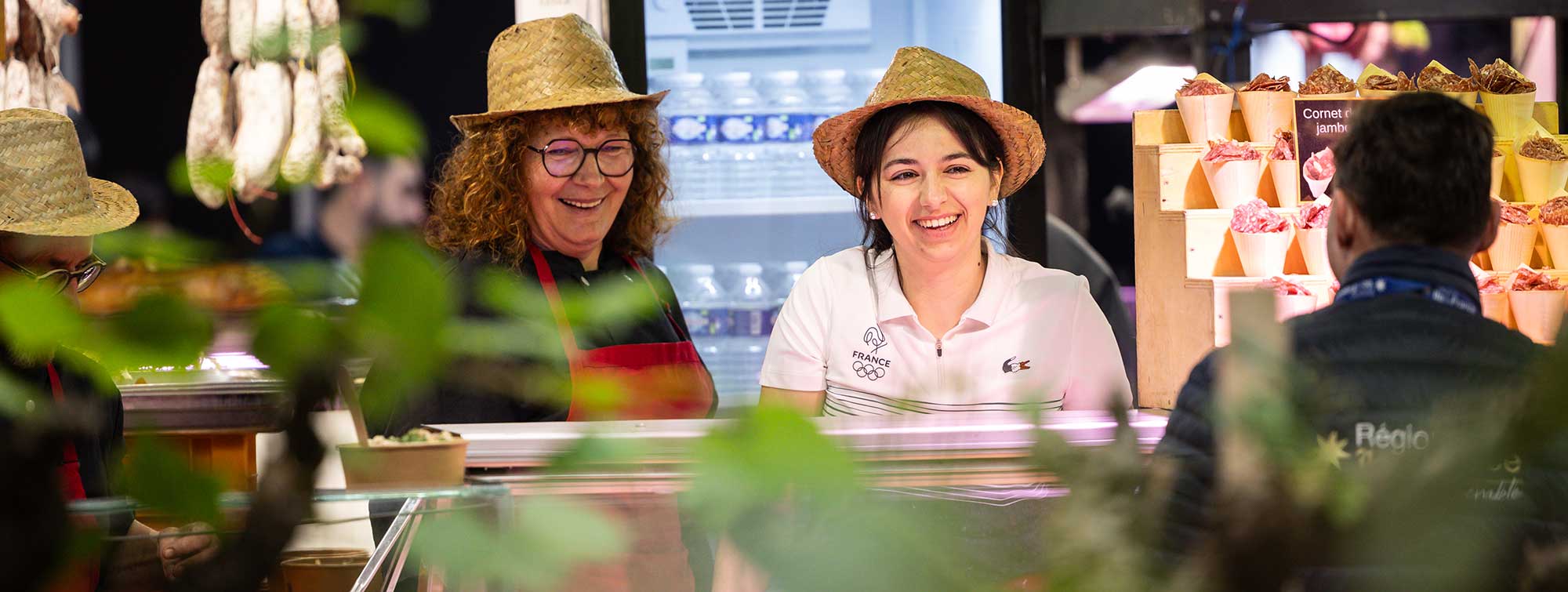 Deux femmes exposantes parlant à un visiteur