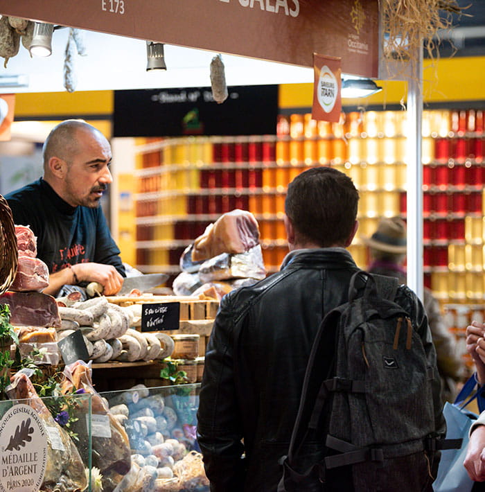 Exhibitor behind his delicatessen stand